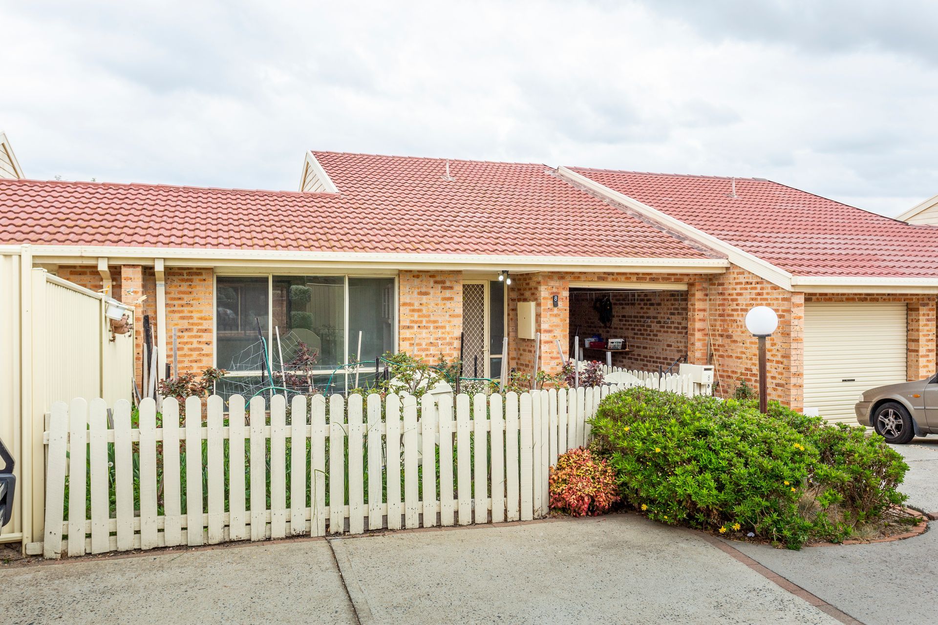 Empty interior room with light green walls, brown carpet, and three open doorways.