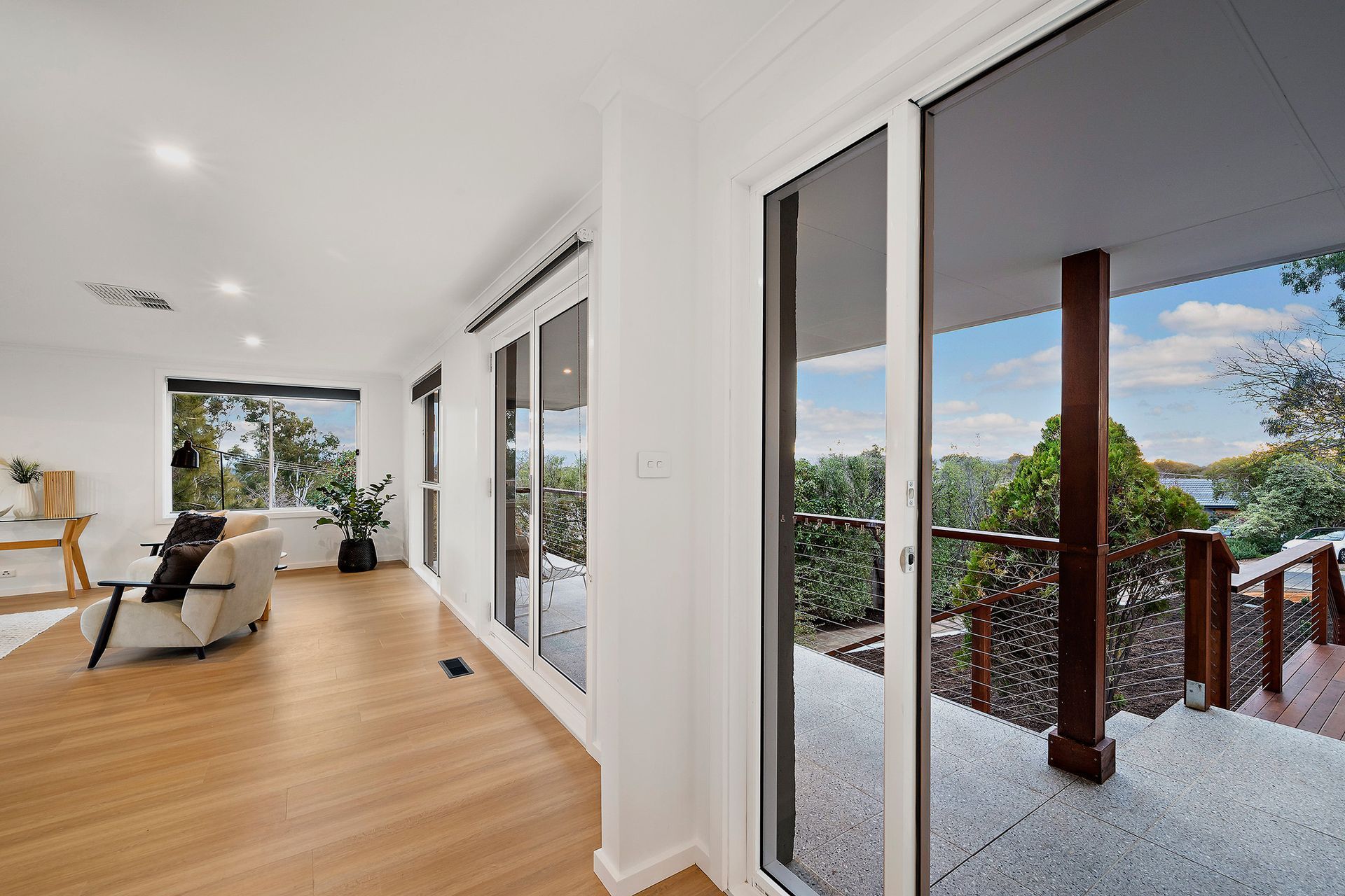 Bedroom with bed, bedside tables, window, and wall art. White walls, gray carpet, and blue bedding.