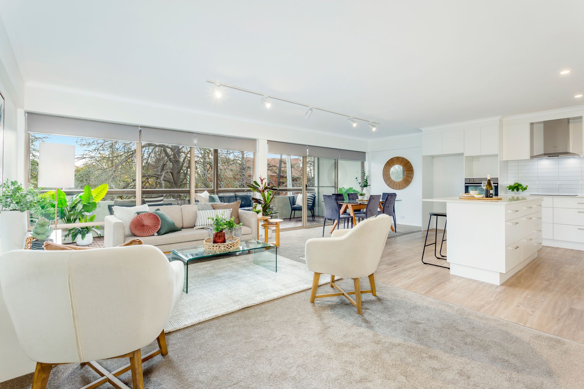 Balcony with grey furniture, plants, and a view of trees and road.