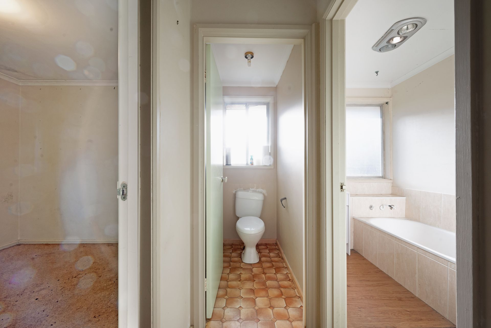 Living room with couch, shelves, boxes; natural light streams in.