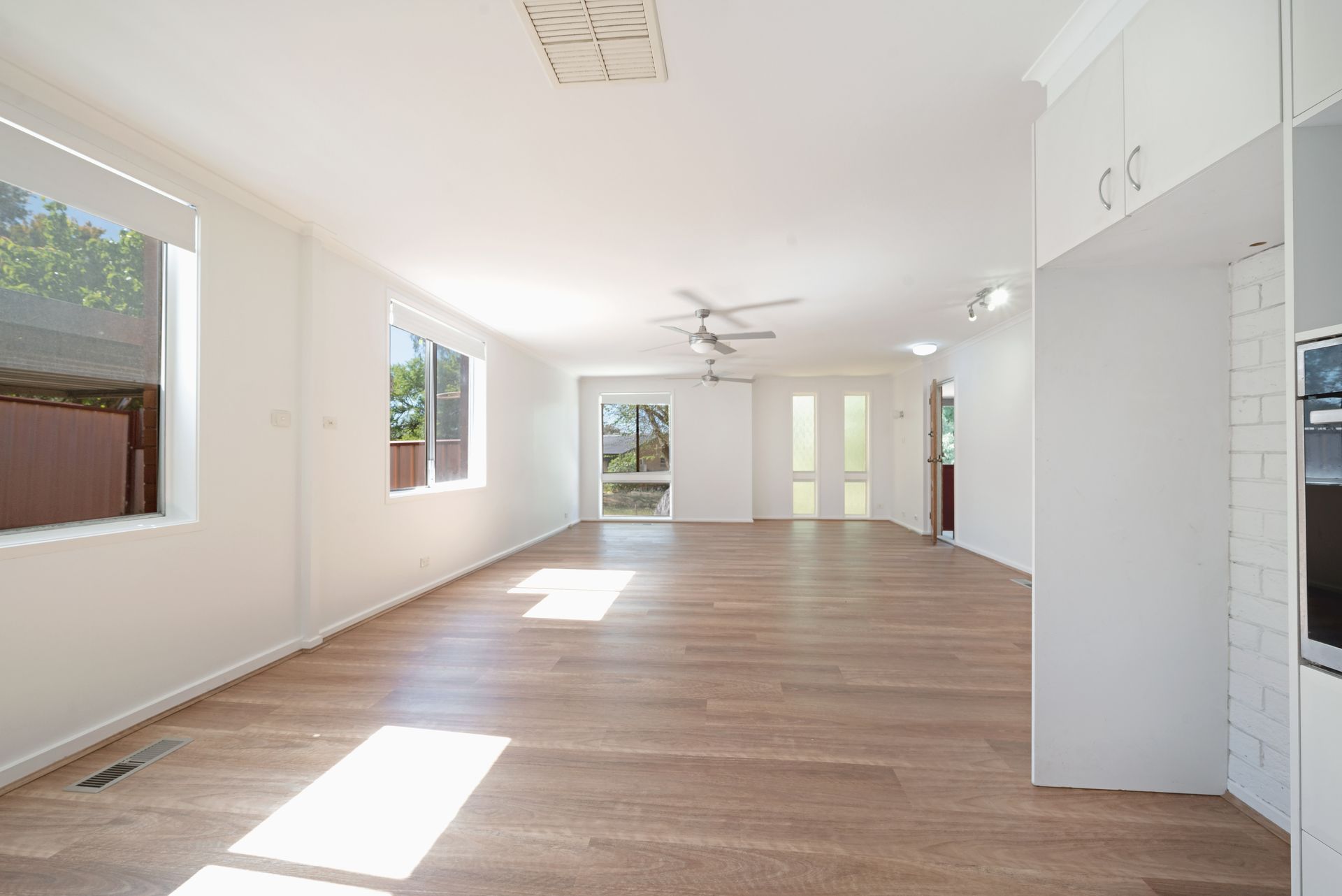White interior room with tall storage cabinets and a screen door to the outside.