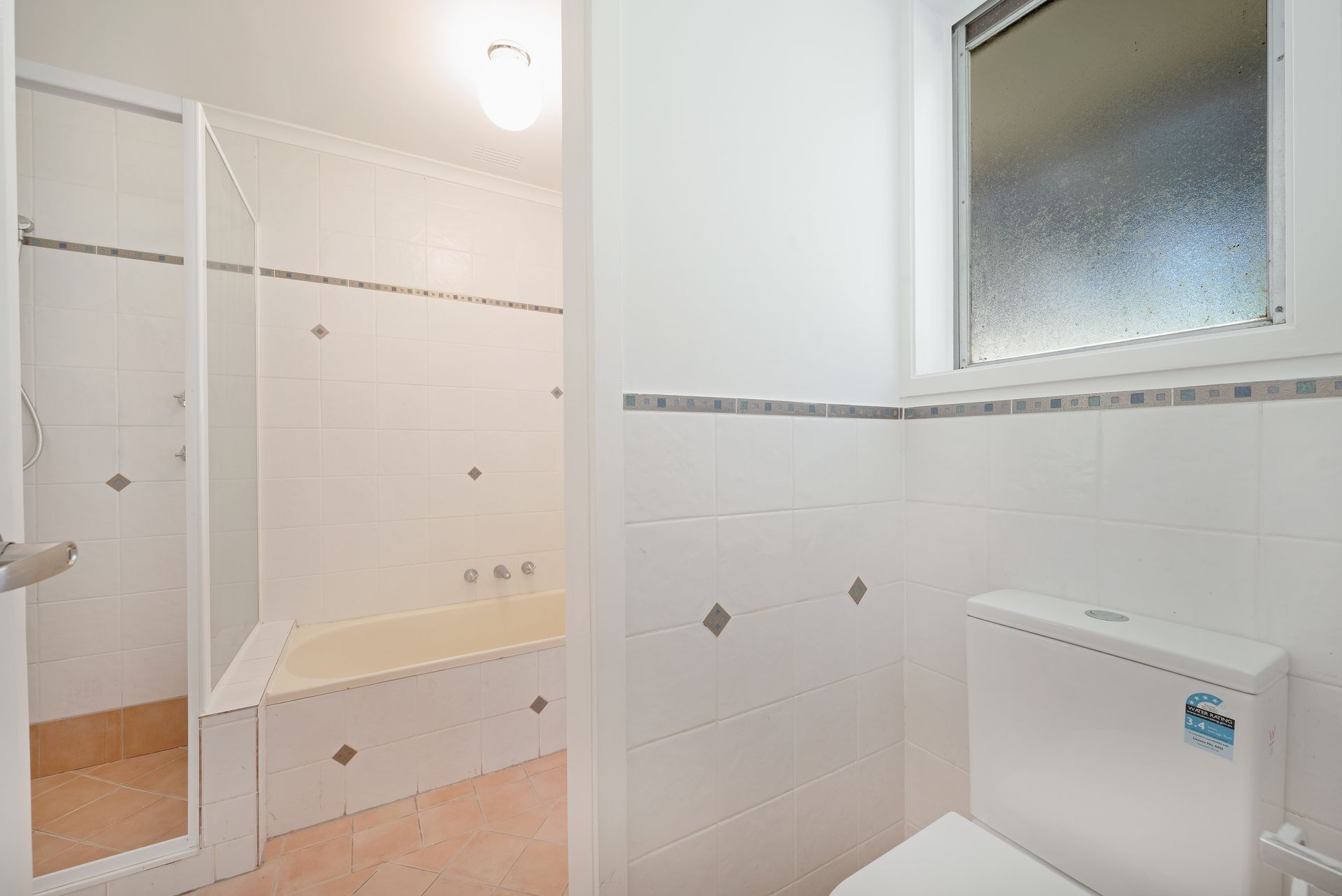 White laundry room with sink, counter, cabinets, and door to outside. Plant and laundry basket are present.