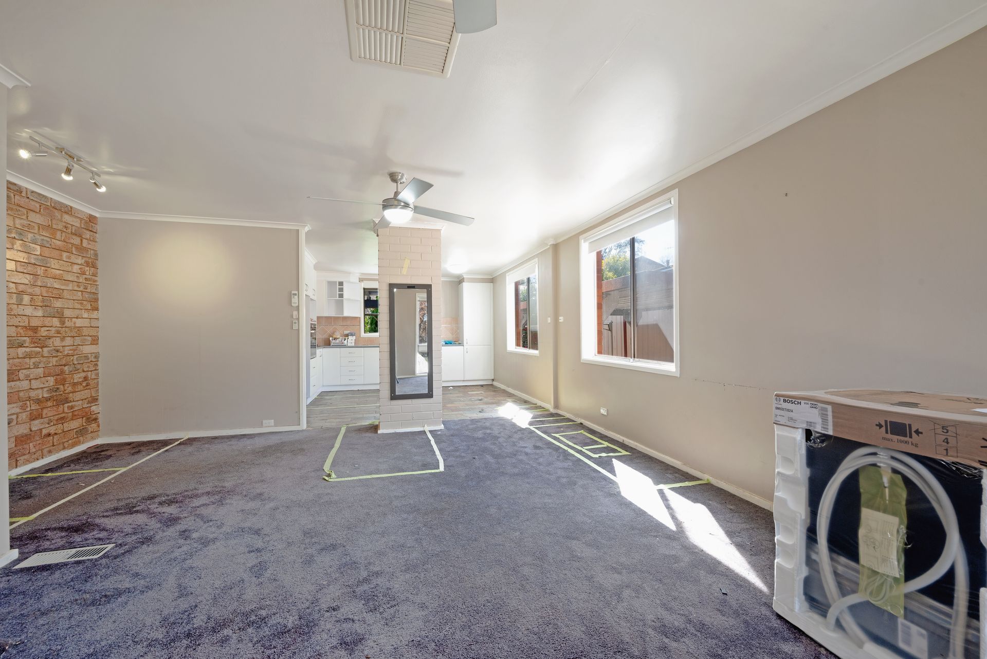 Empty interior room with exposed brick and tile flooring under construction.