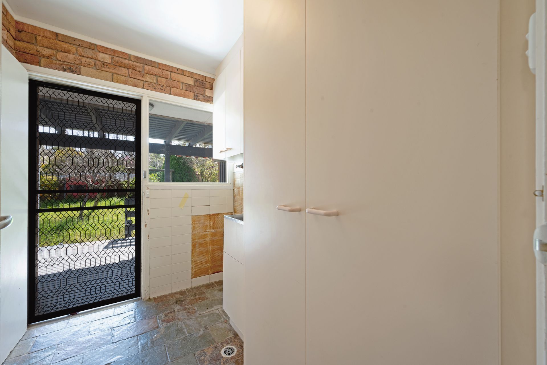 Bedroom with dusty blue carpet, pink curtains, a ceiling fan, and a hallway entrance.