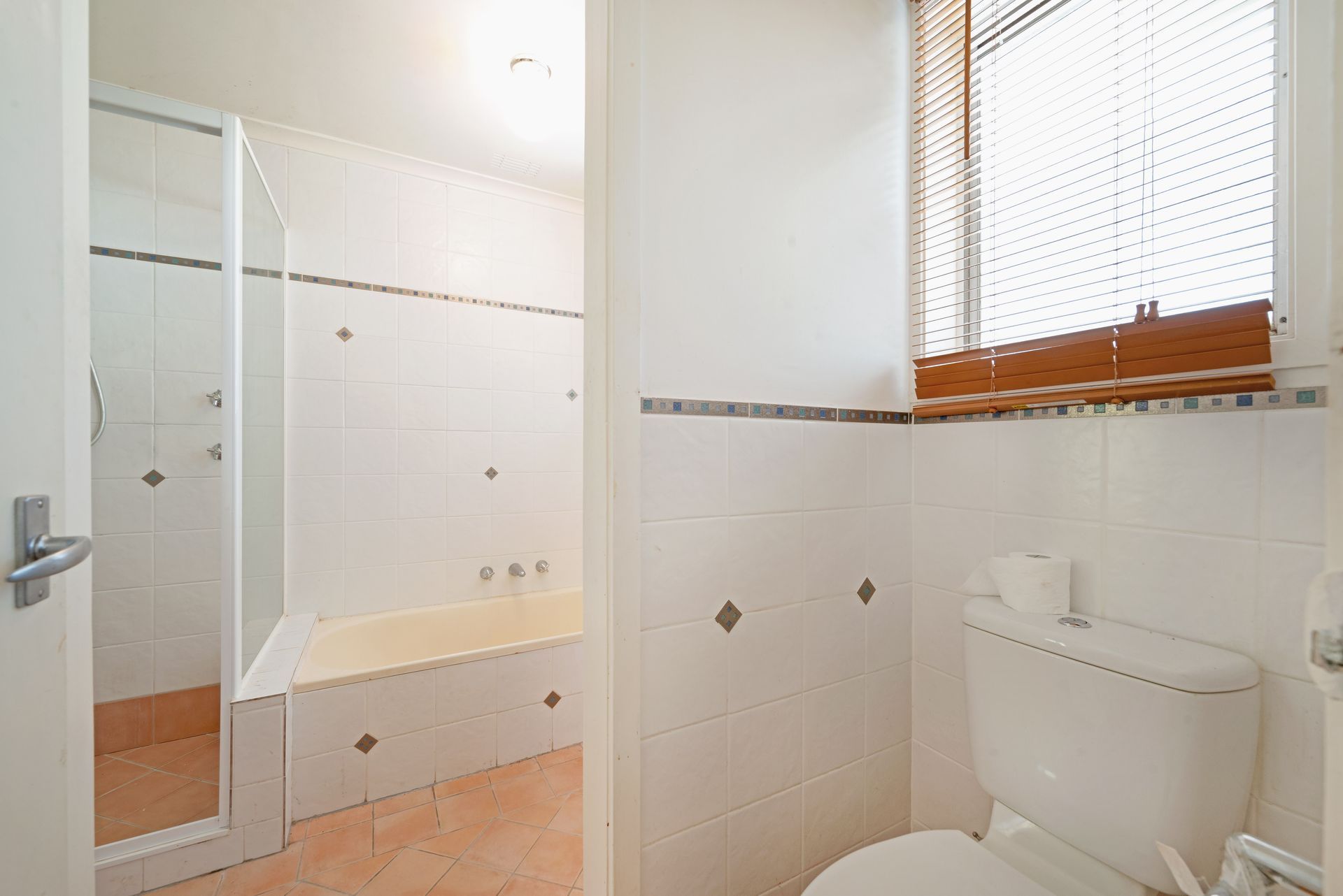 Laundry room with washing machine, sink, shelves holding cleaning supplies, and laundry baskets.