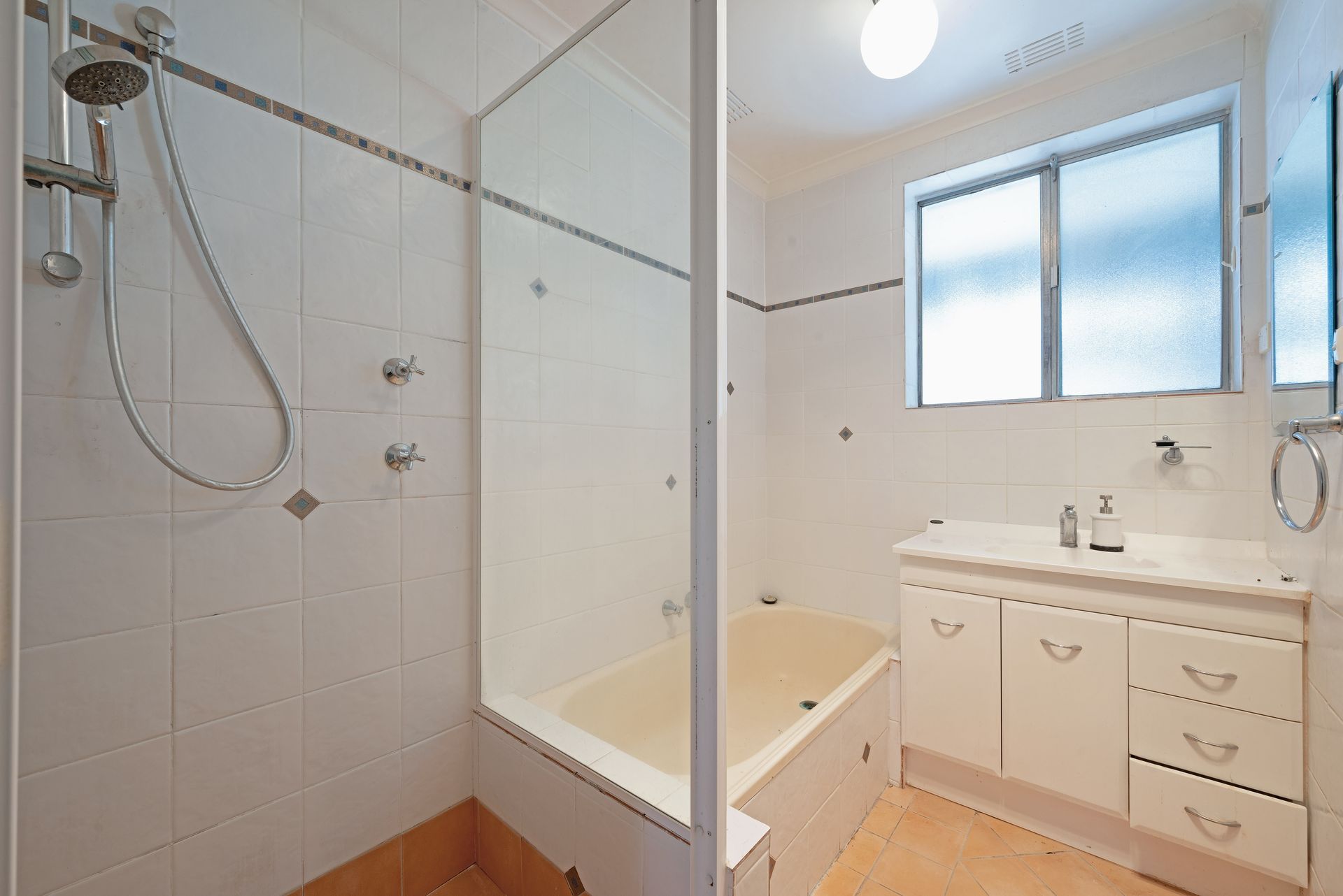 Dilapidated utility room with a sink, counter, and peeling wallpaper.