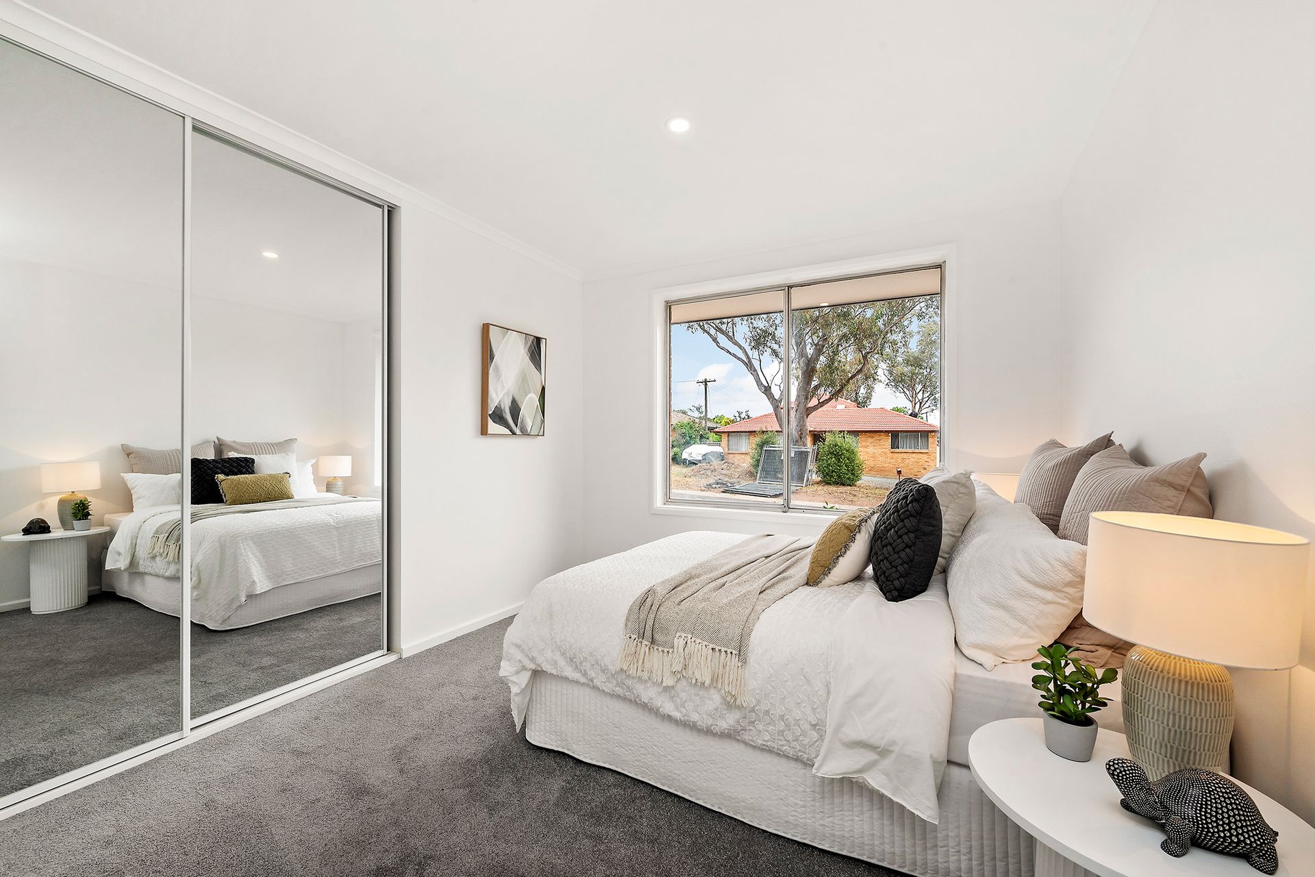 Brick home with a small lawn, steps to the front door, and a garage on a sunny day.