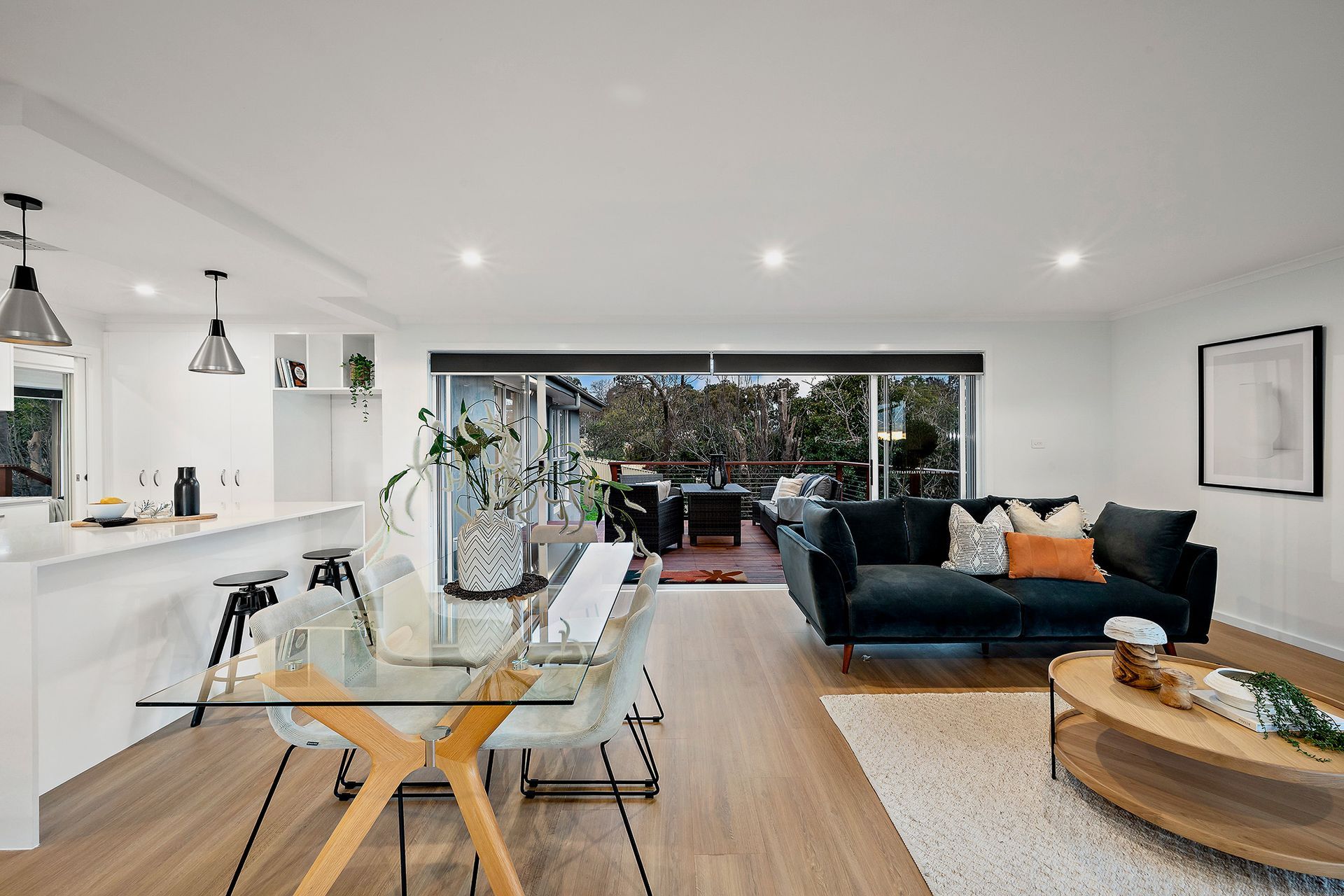 Kitchen with white cabinets, gray countertop, and access to a deck and backyard via glass doors.
