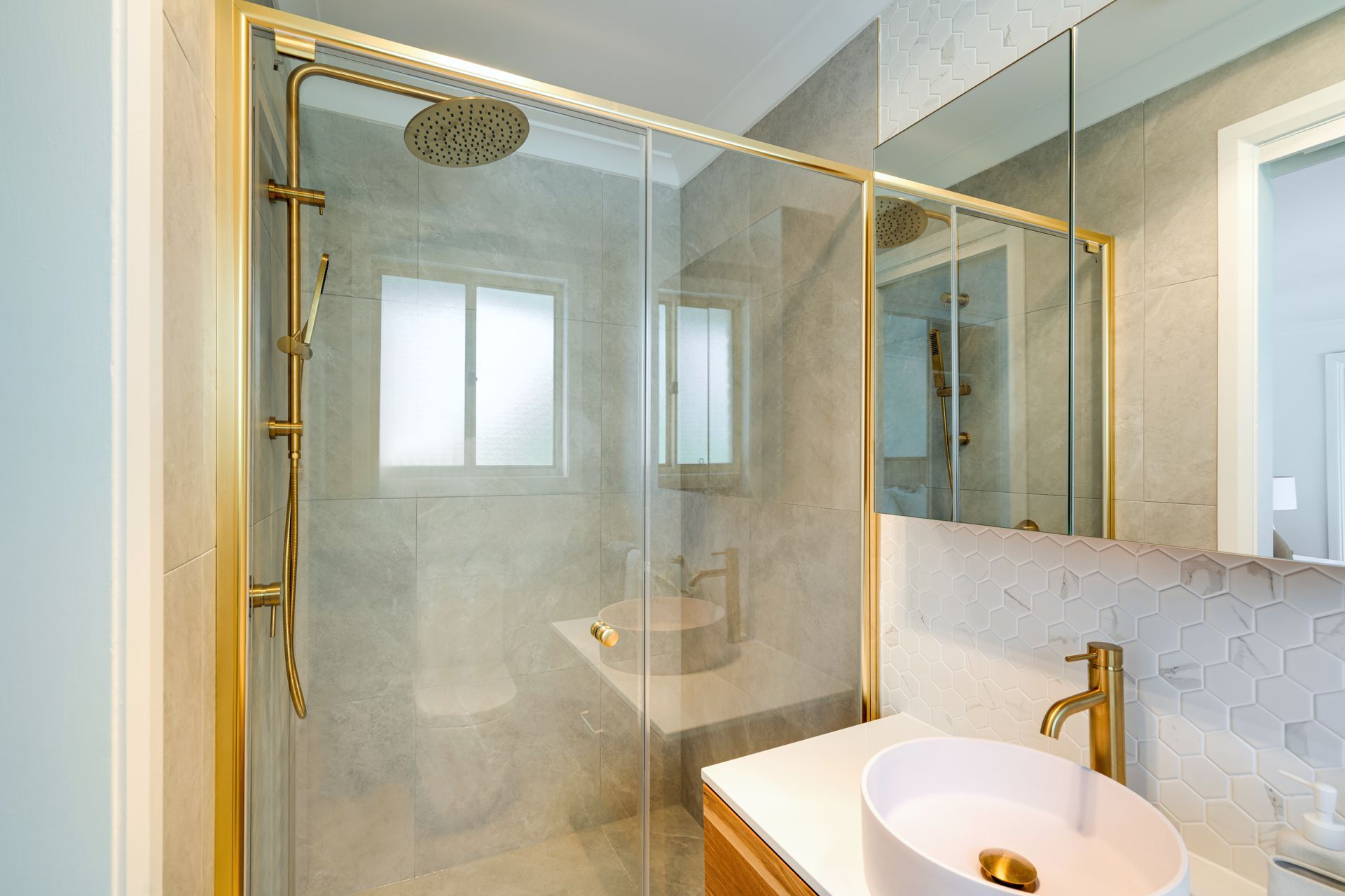 Modern kitchen with dark gray cabinets, white countertops, and wood flooring.