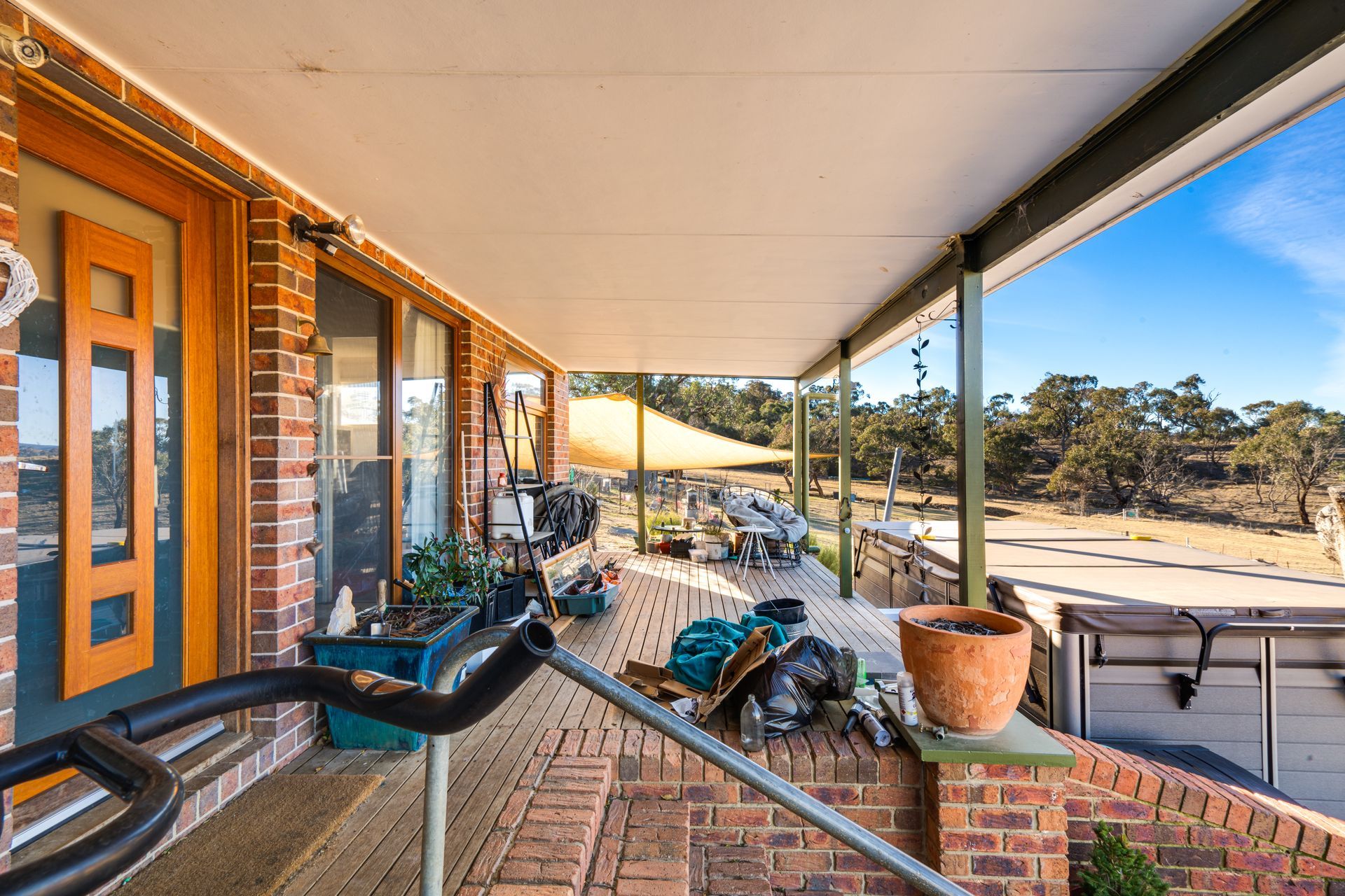 Interior entryway with open wooden door, tiled floor, carpeted living area, and a view of a tree outside.
