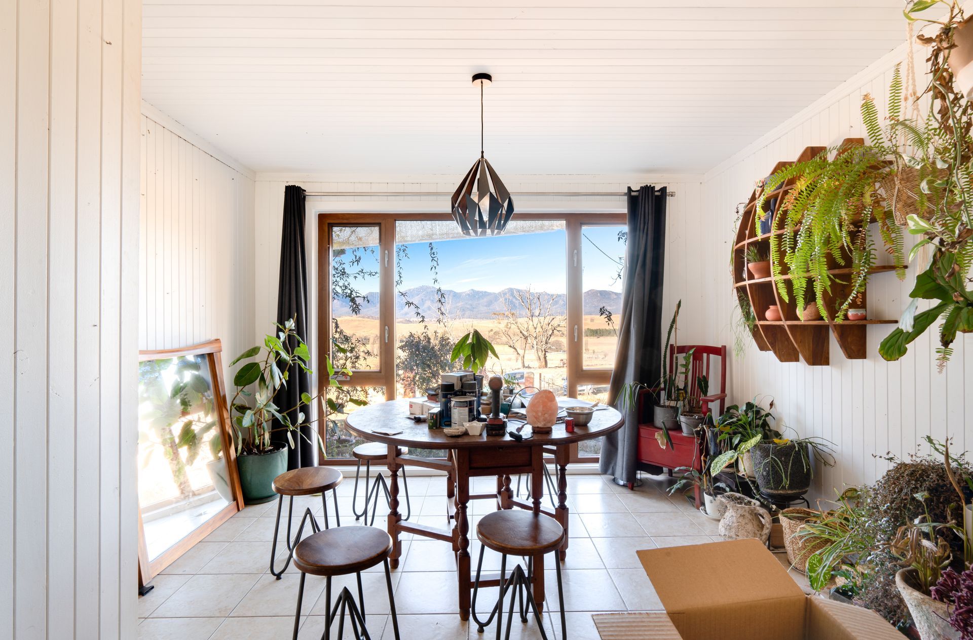 Interior entryway with open wooden door, tiled floor, carpeted living area, and a view of a tree outside.