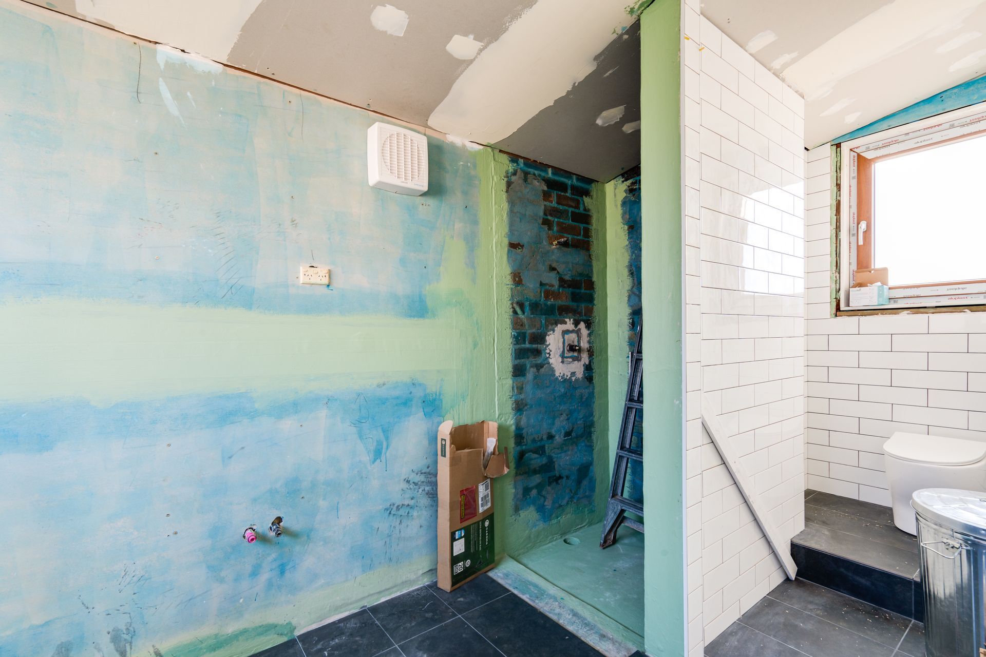 Interior entryway with open wooden door, tiled floor, carpeted living area, and a view of a tree outside.