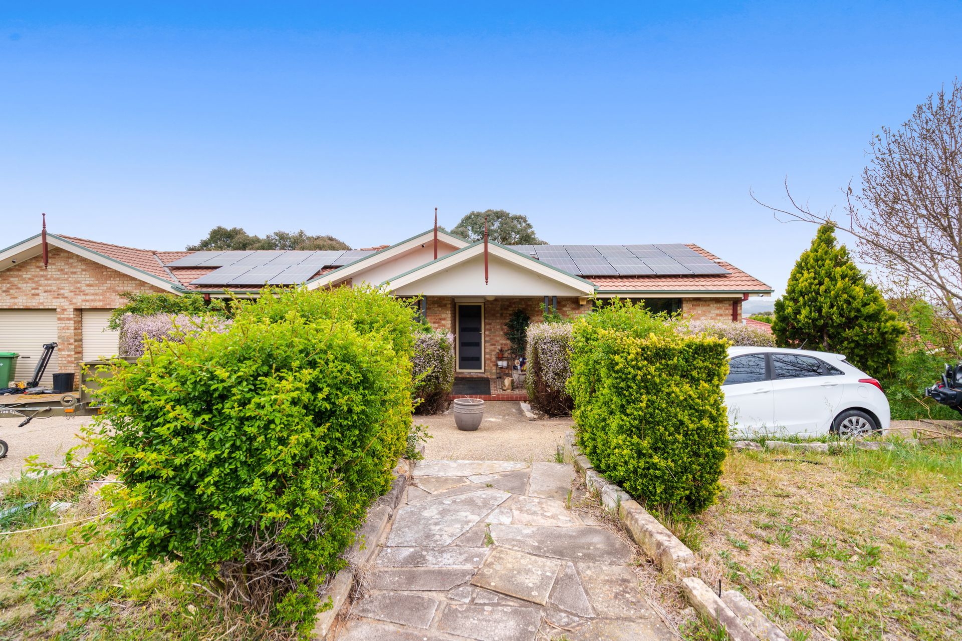 Dilapidated utility room with a sink, counter, and peeling wallpaper.