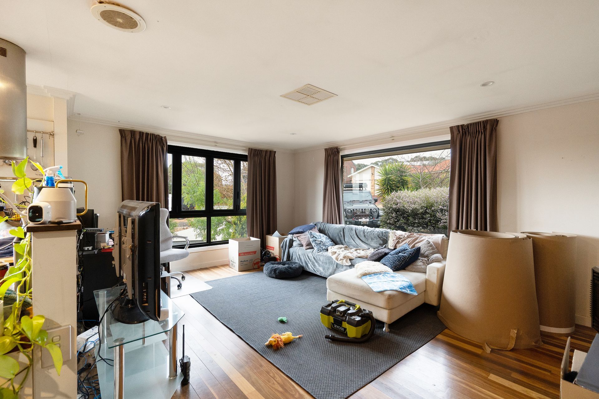 Bathroom with wooden vanity, sink, mirror, and open door to the left.