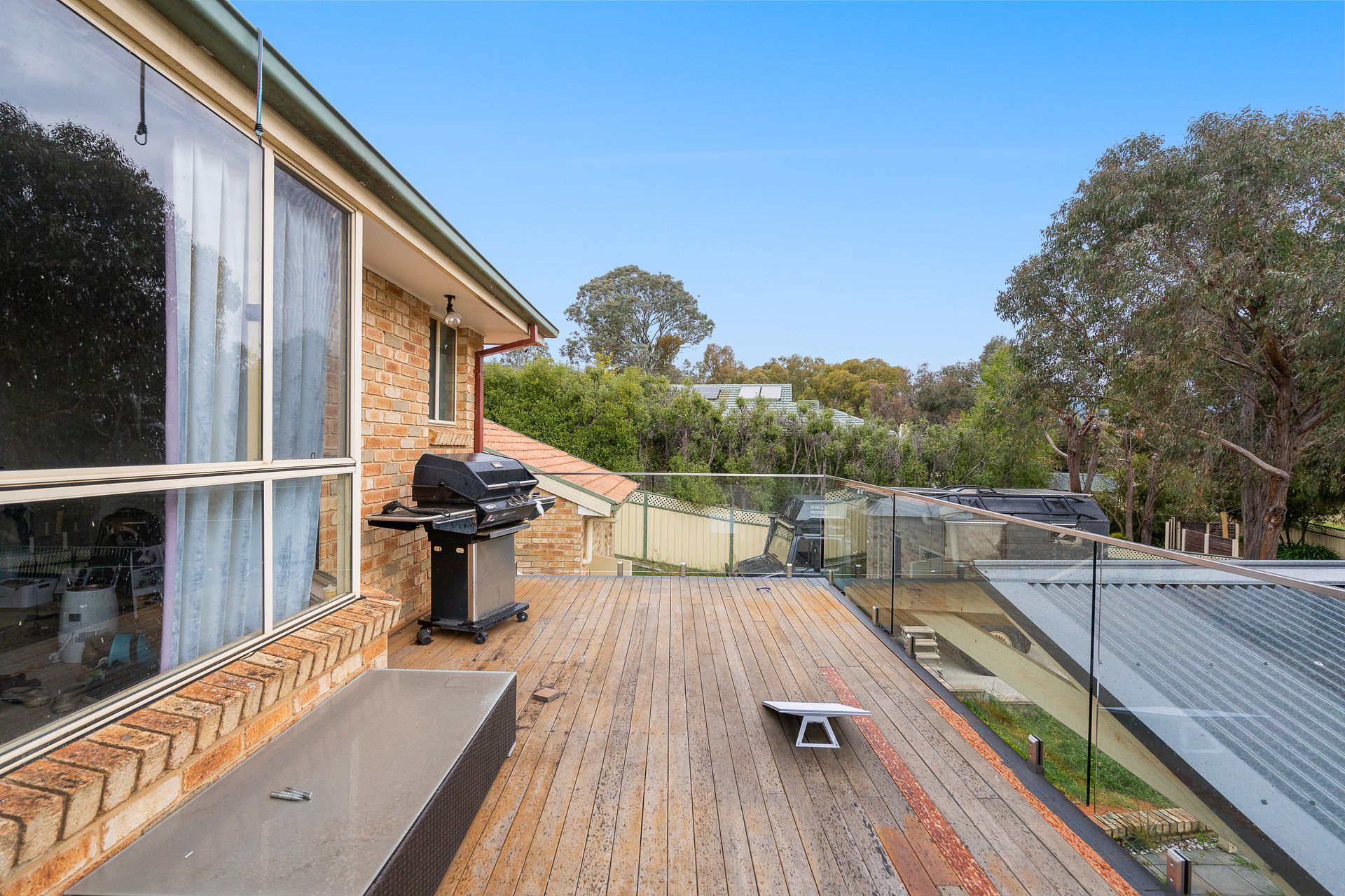 A messy kitchen with grey cabinets, a window, and appliances on the counter.