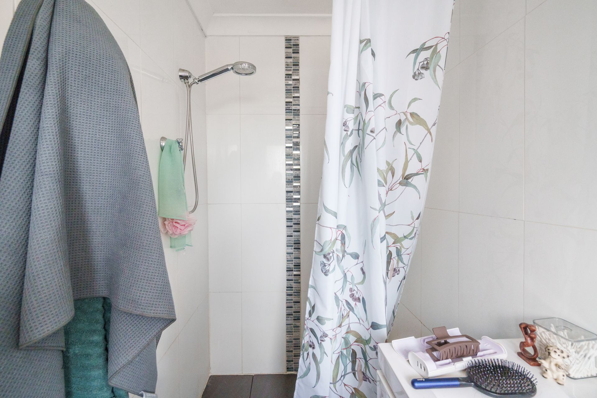 A messy kitchen with grey cabinets, a window, and appliances on the counter.