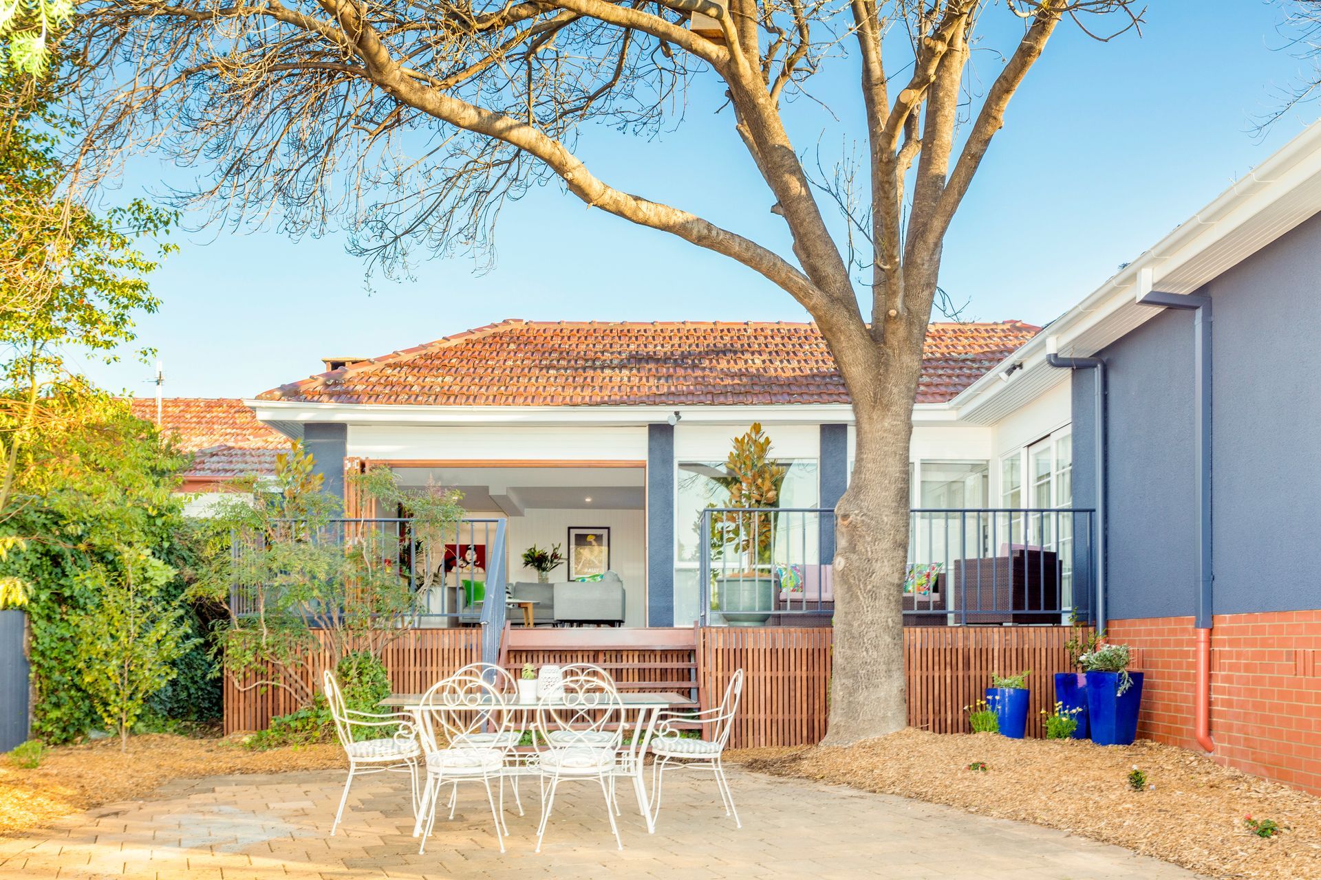 Bright kitchen with white counters, stools, and green vintage stove.