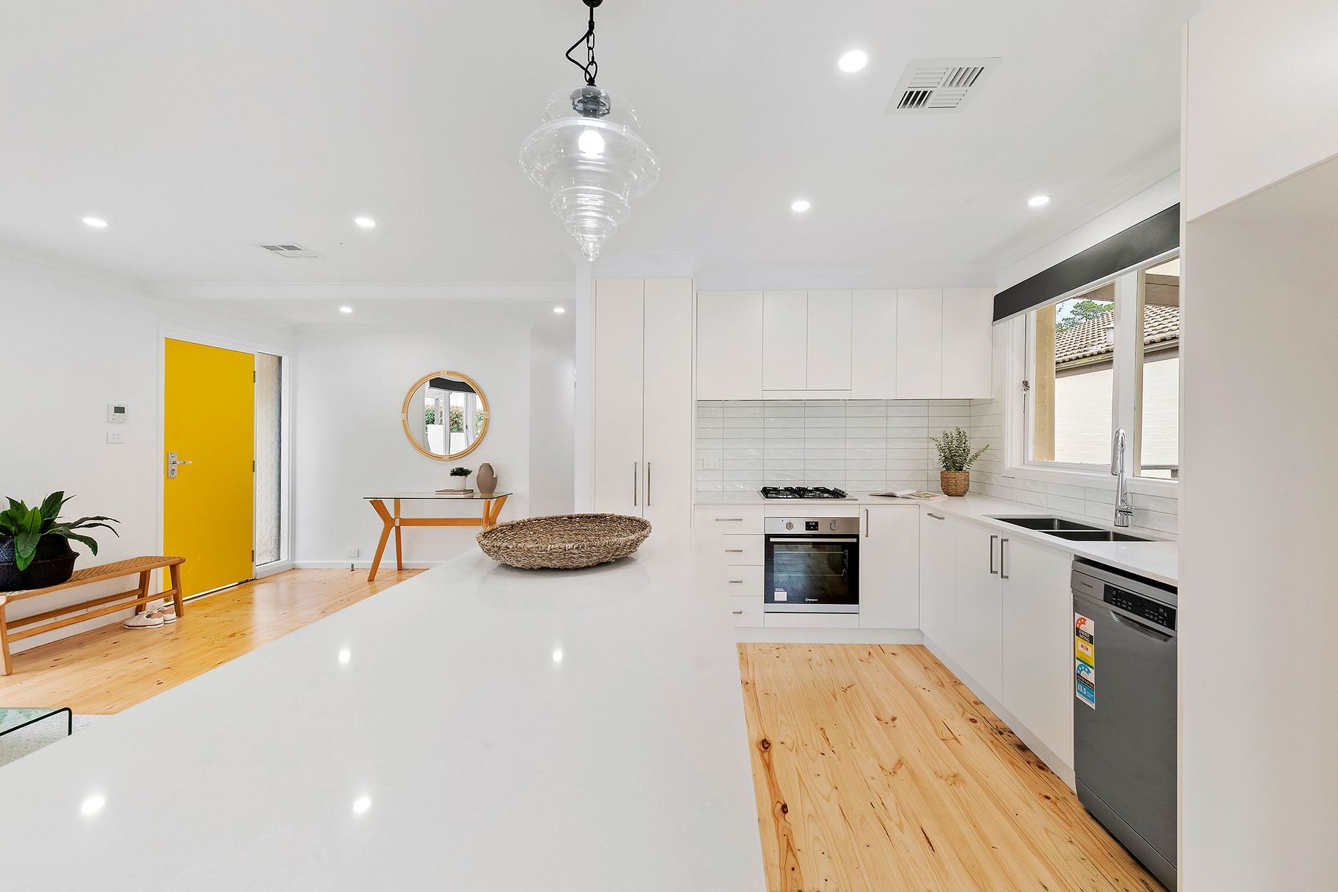 Bedroom with gray walls, bed with pillows, nightstands, and window with a shade.