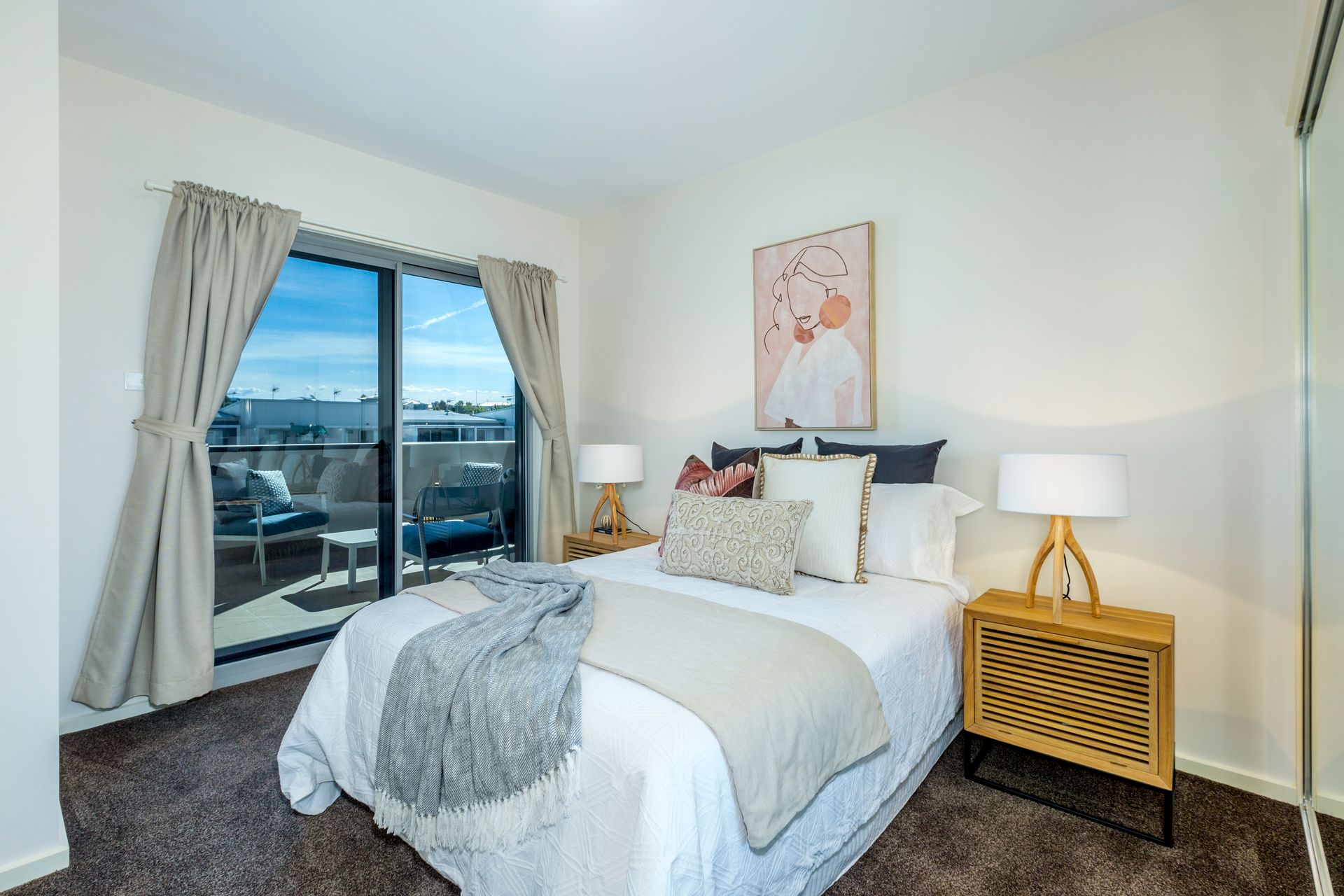 Bedroom with bed, nightstands, and sliding door to balcony.