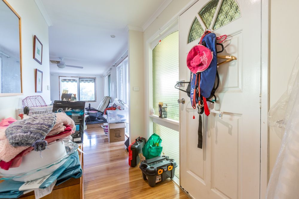 Cluttered bedroom with a bed, wardrobe, and items strewn about. A Canadian flag hangs on the wall.