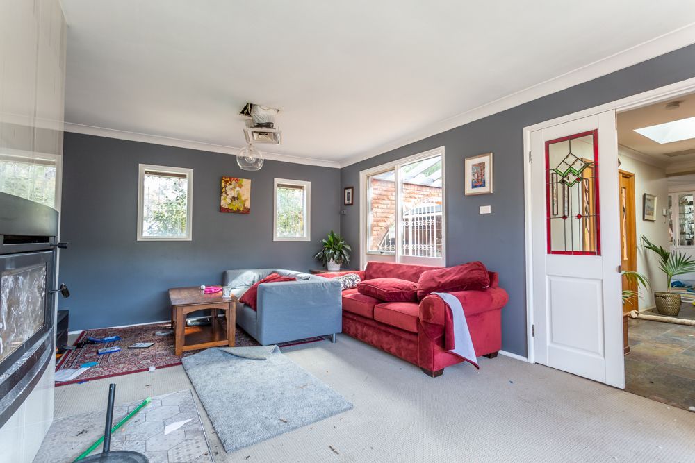 Swimming pool with brick surround, next to a brick house under a blue sky.