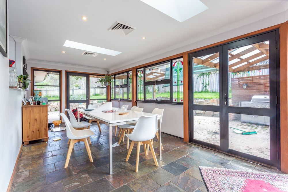 Dining room with table, chairs, windows, and skylights. Interior, natural light, and view of the backyard.