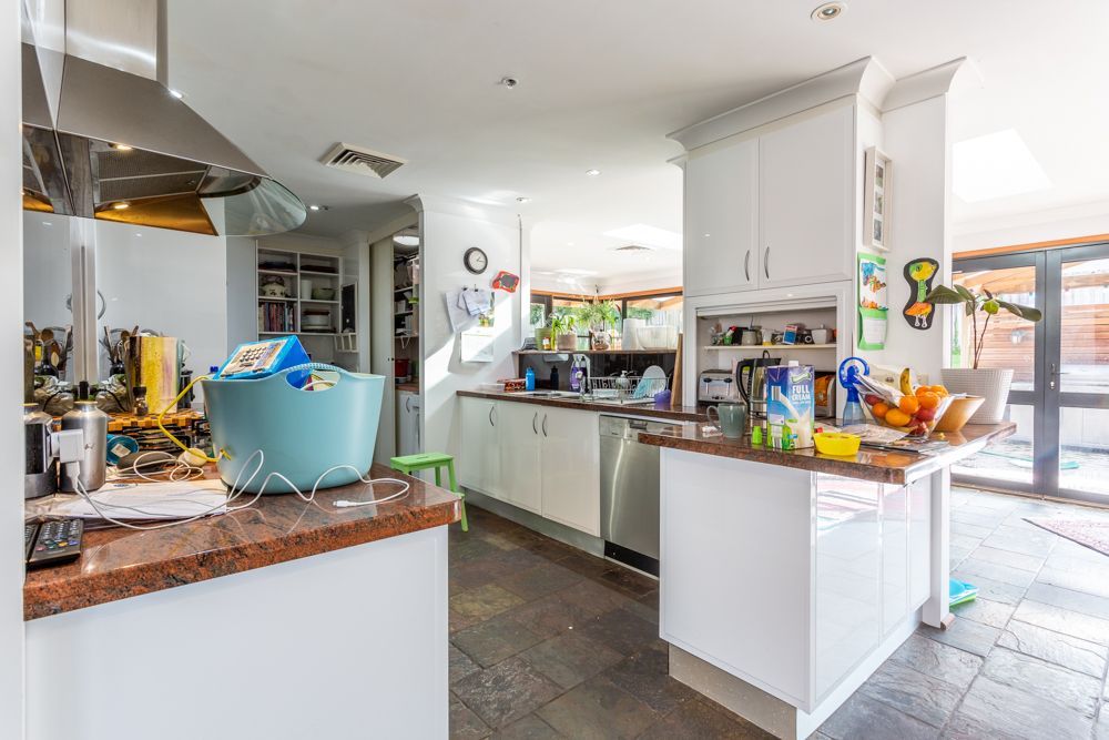 Living room with fireplace, red couch, gray walls, and small windows.