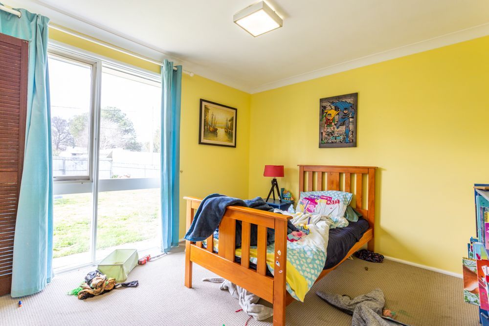 Spacious kitchen with white cabinets, dark countertops, and stainless steel appliances; leads to living area.