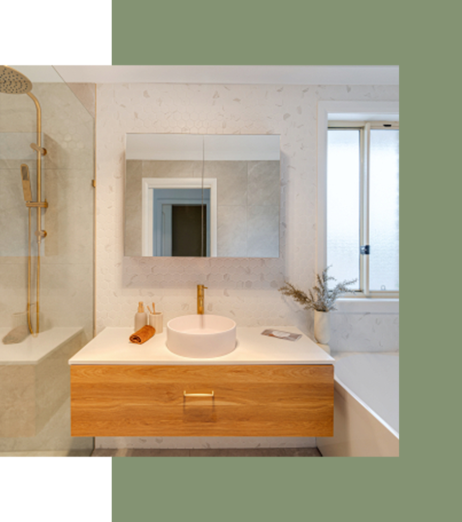 Modern bathroom with wood vanity, gold fixtures, marble walls, and frosted window.