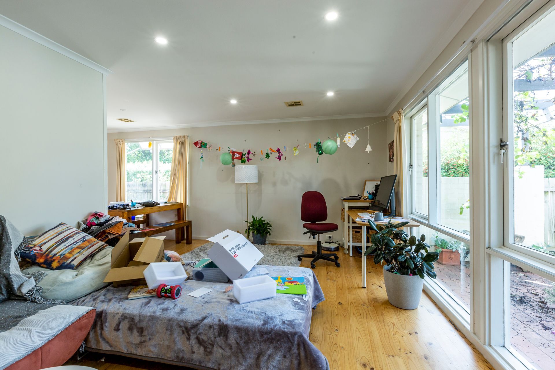 Living room with white couches, TV, and miscellaneous items scattered about.