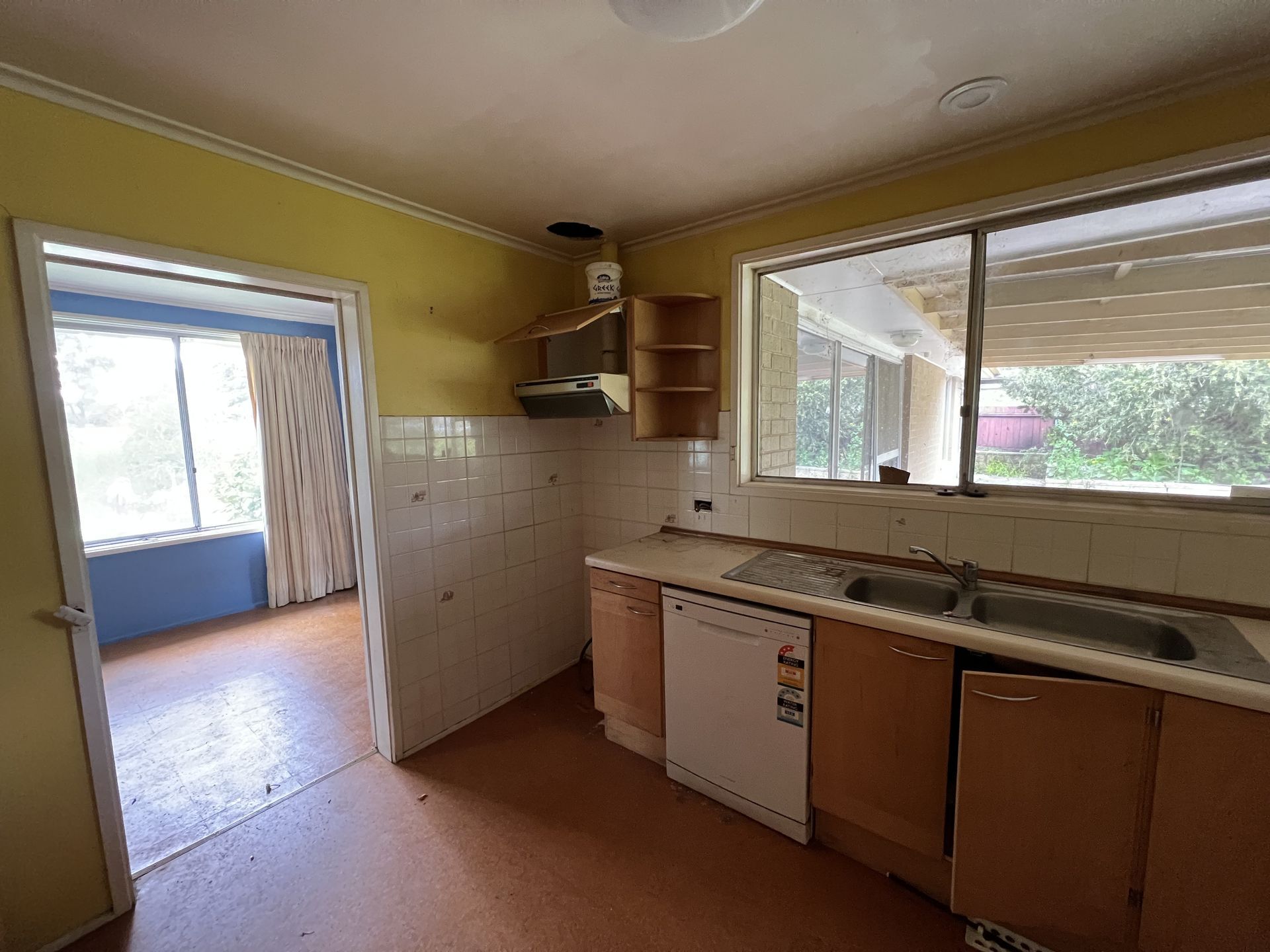 Laundry room with washing machine, sink, shelves holding cleaning supplies, and laundry baskets.