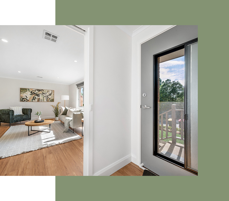 Interior view: entrance doorway leading to a living room with light walls and wood floors.