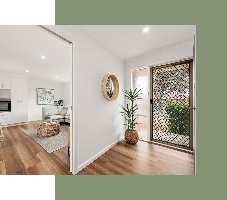 Interior hallway with wooden floor and an open door to living area.