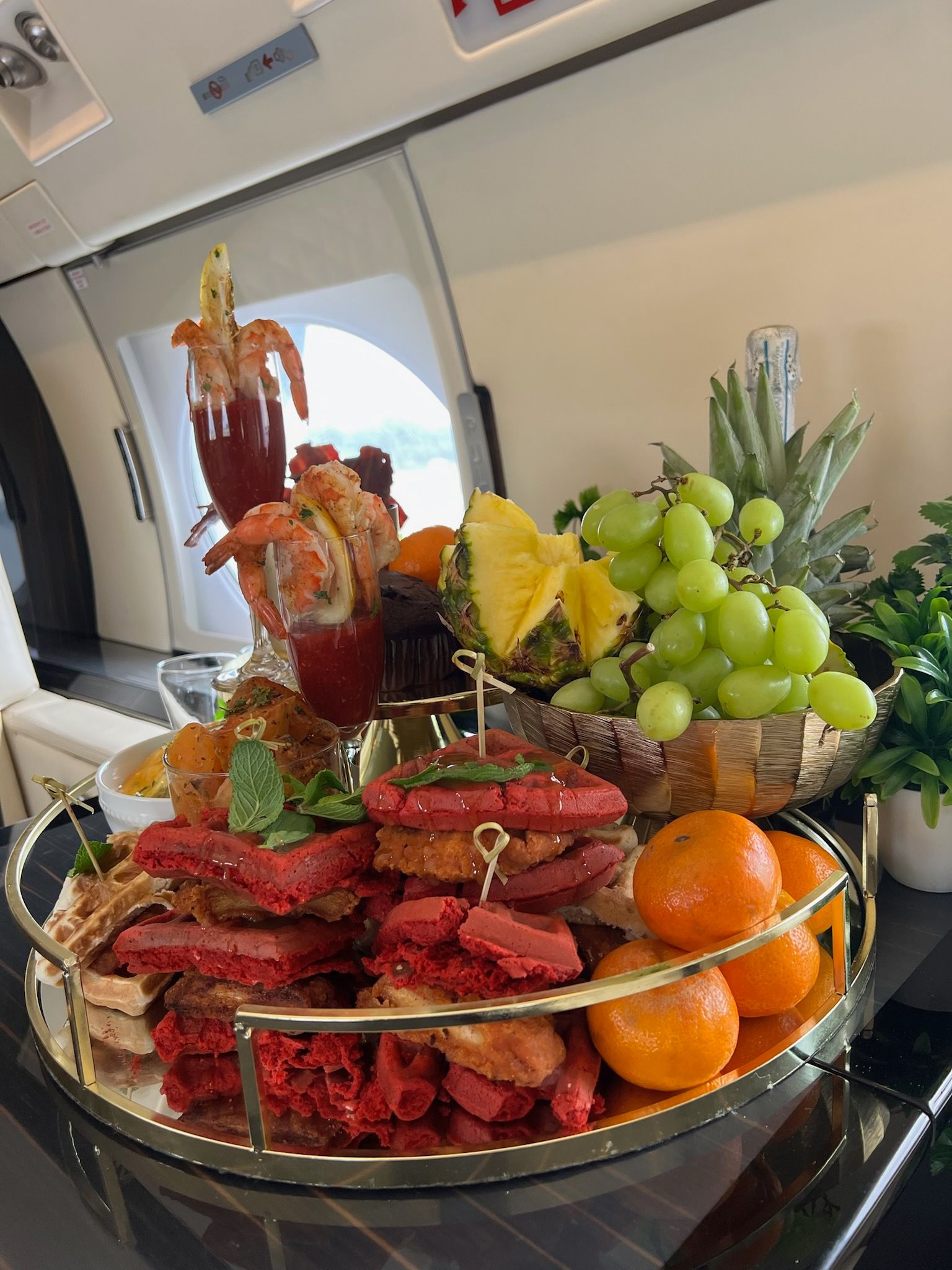 A tray of food and fruit on a table in a kitchen.