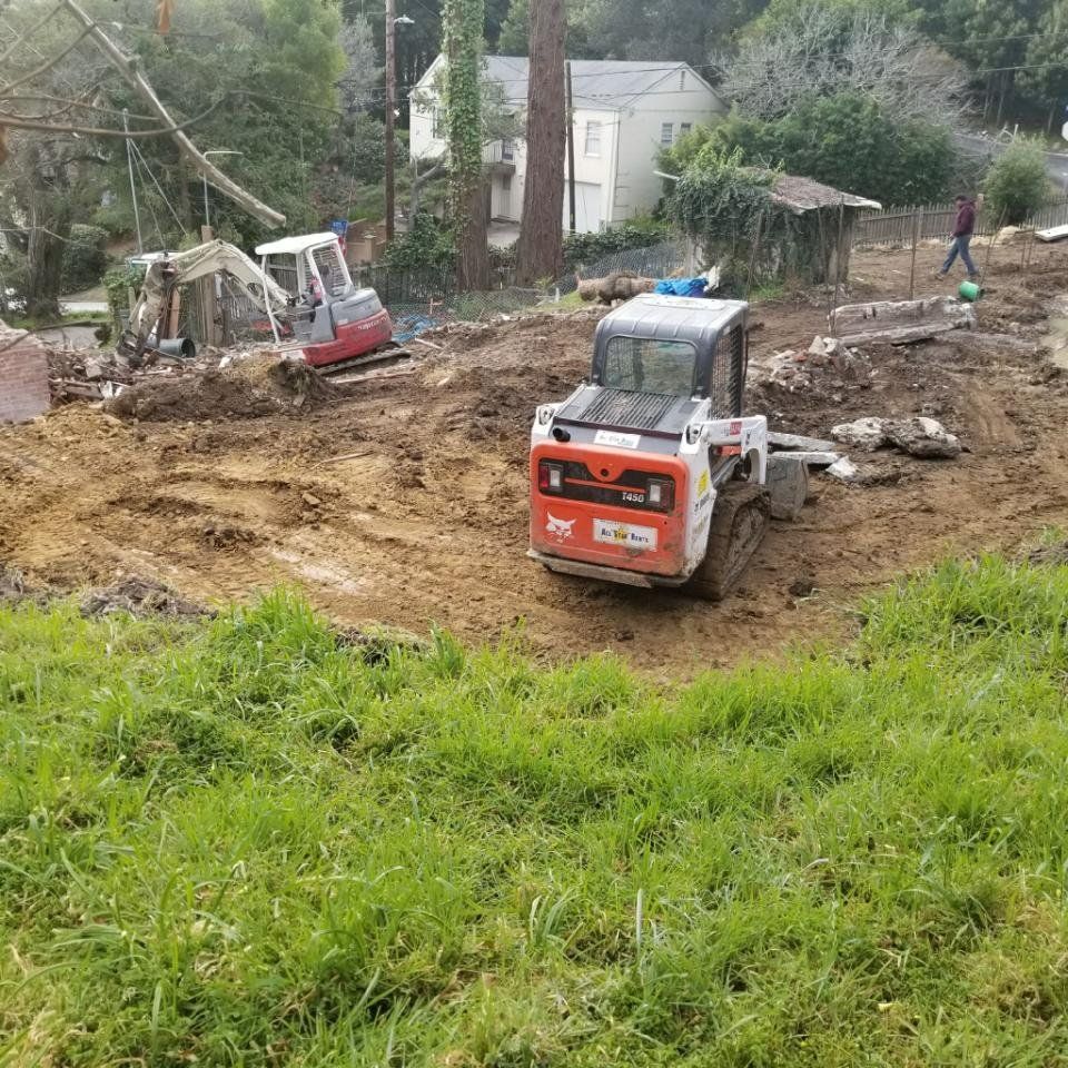 A bulldozer is driving through a dirt field.
