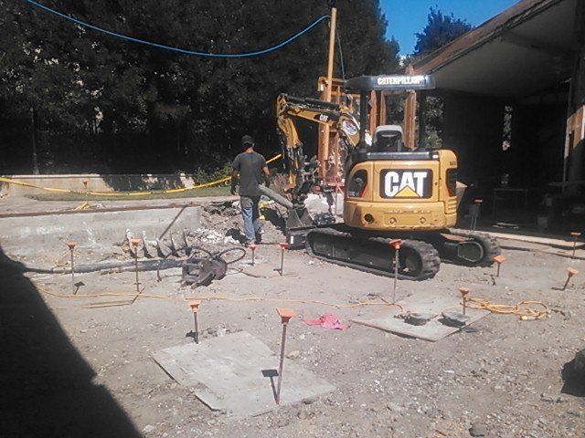A construction site with a cat excavator in the foreground