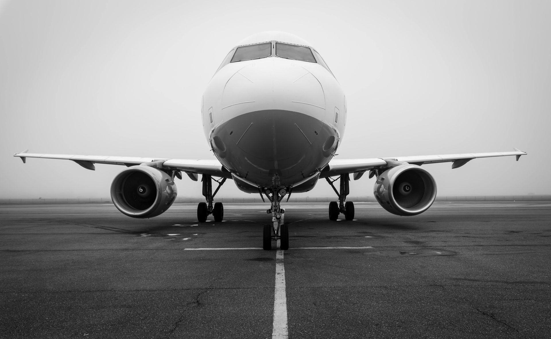 A black and white photo of an airplane on a runway.
