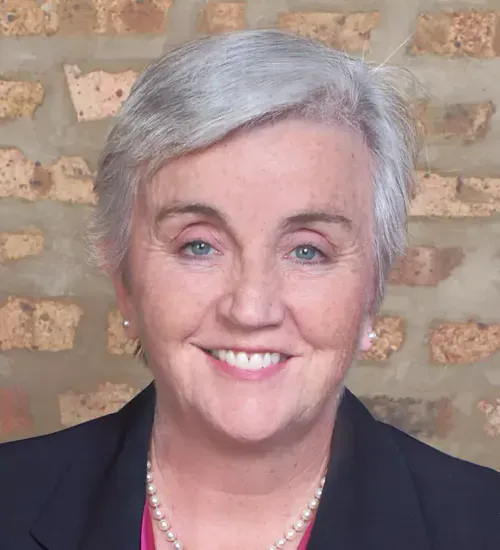 A group of people are sitting at desks in an office.