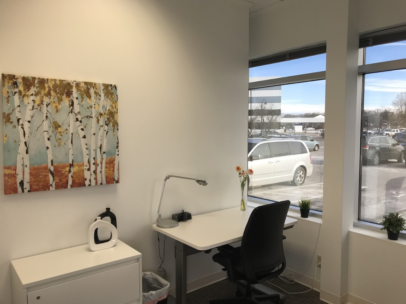 A group of people are sitting at desks in an office.