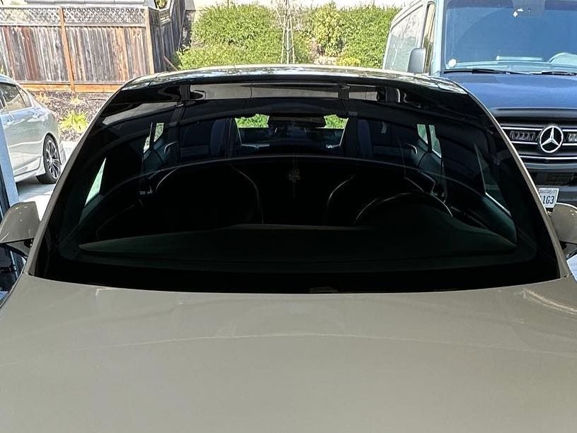 A yellow sports car is parked in front of a wooden building.