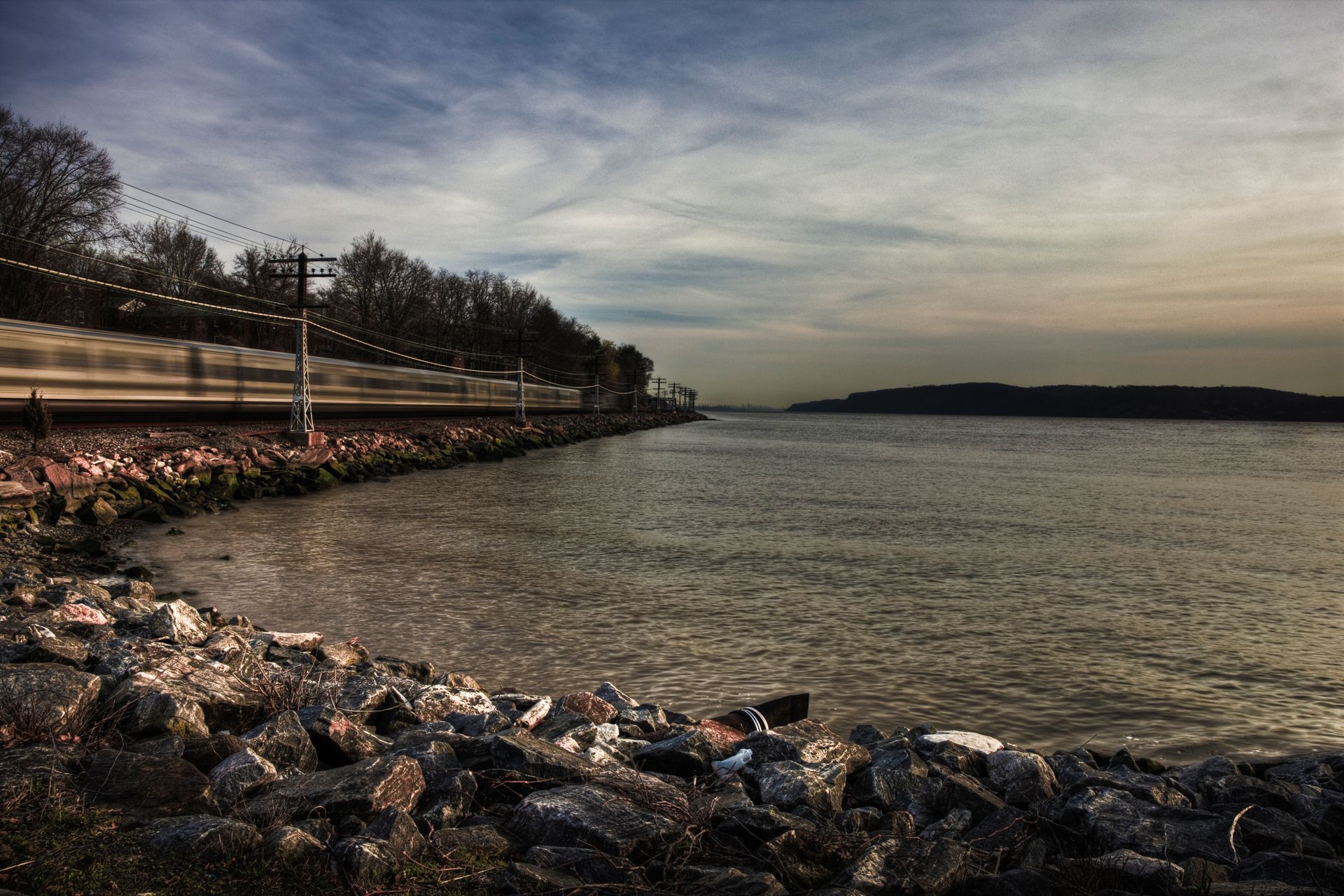 A train is going down the tracks next to a body of water