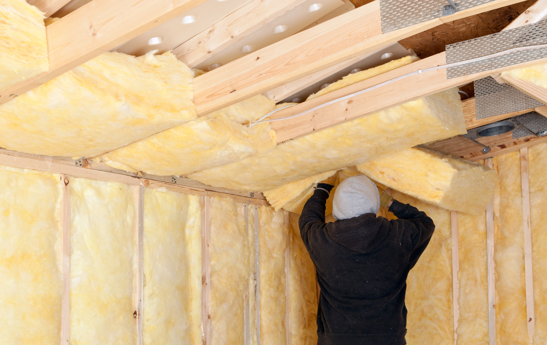 A man is insulating the ceiling of a house.