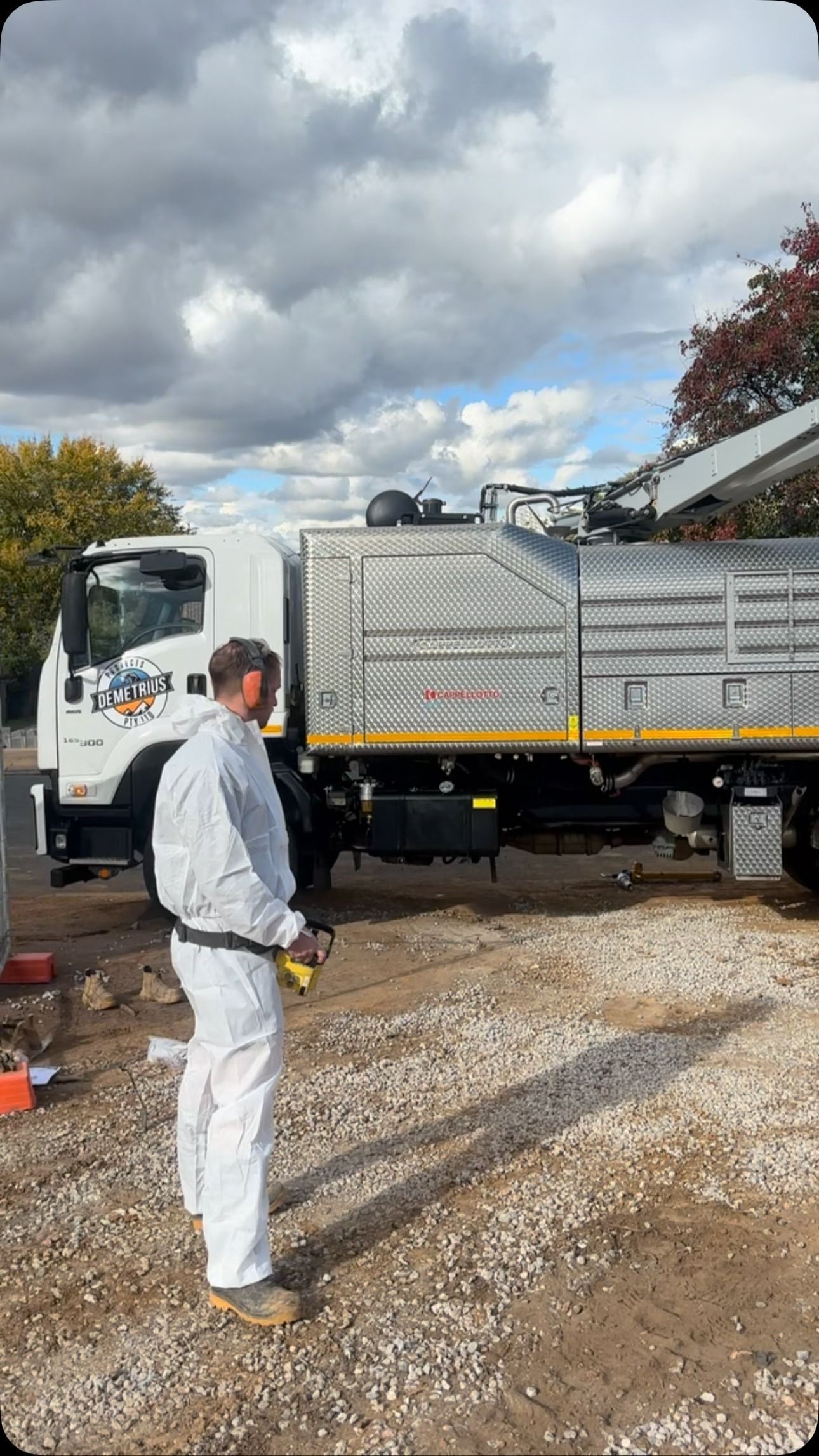 Man in White Protective Suit Stands — Demetrius Projects in Queanbeyan East, NSW
