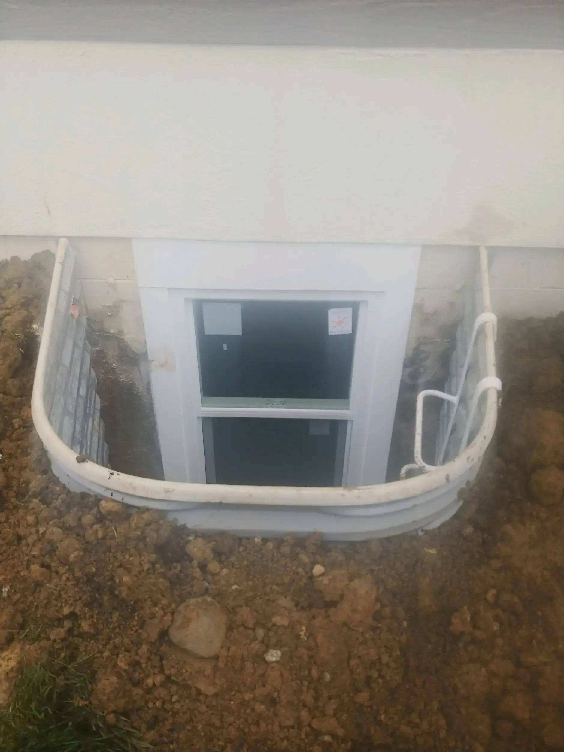 There is a window in the basement of a house.