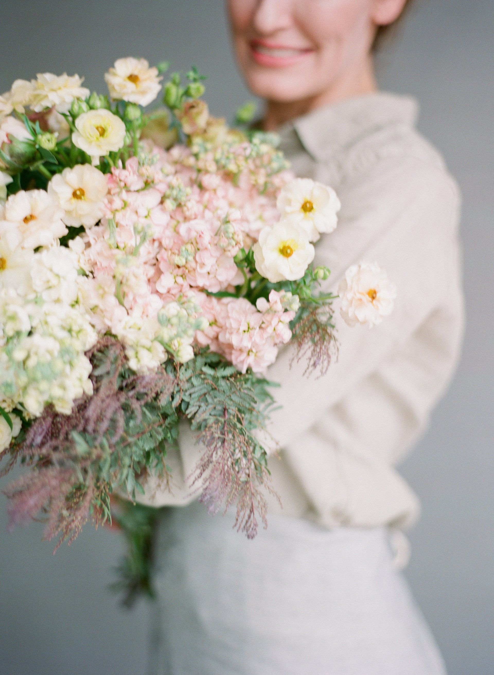 A woman is holding a bouquet of flowers in her hands.