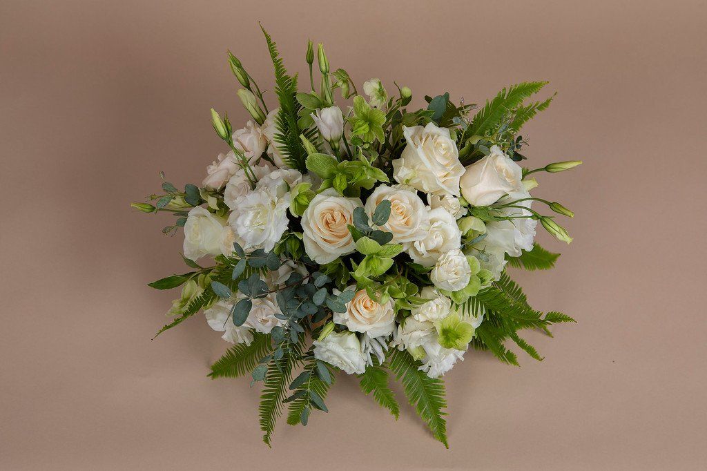 A bouquet of white flowers and greenery on a table.