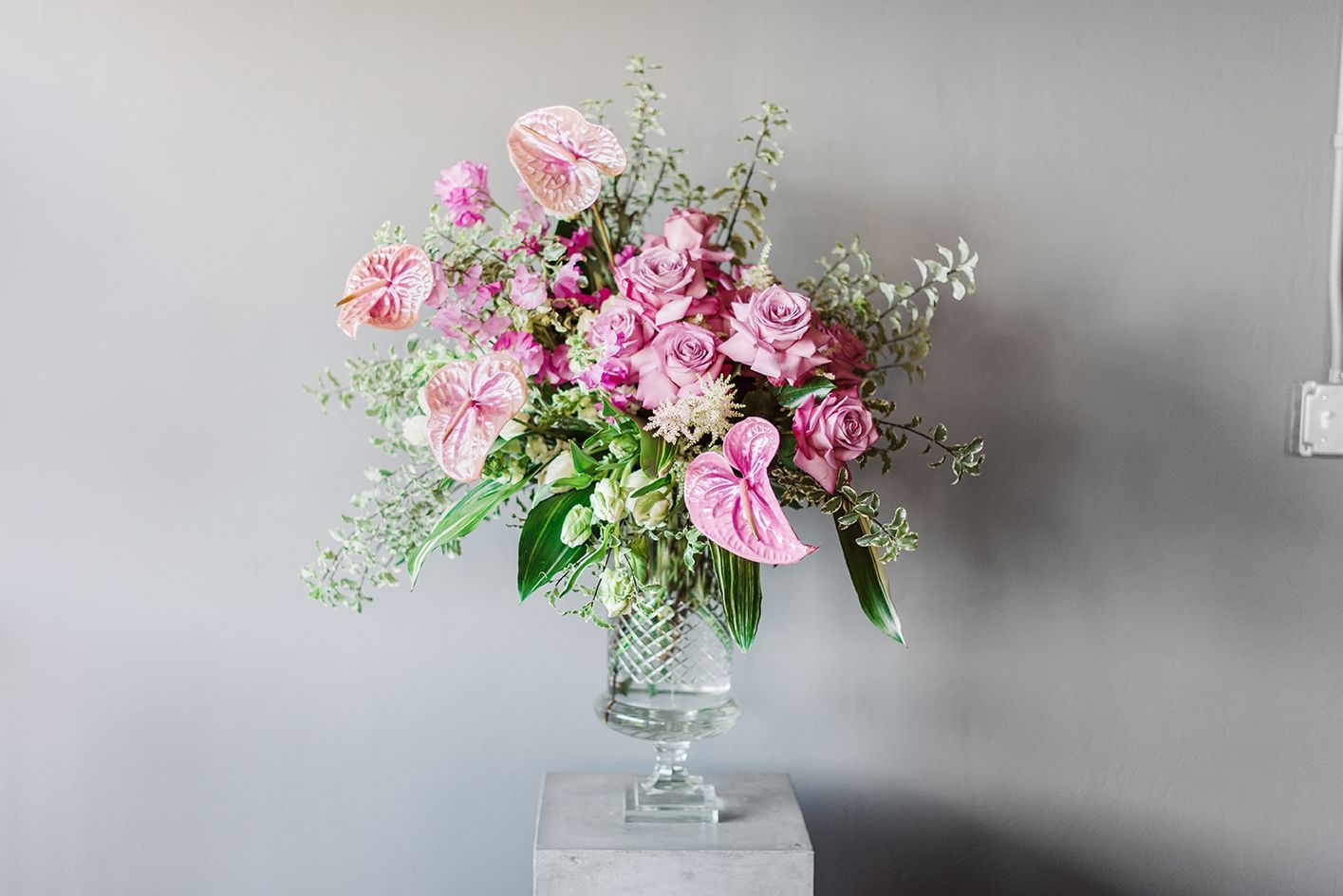 A vase filled with pink flowers is sitting on a table.