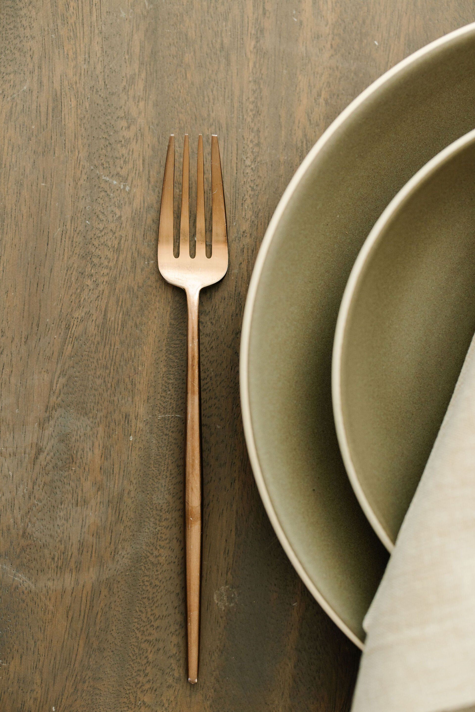 A fork is sitting next to a plate on a table.