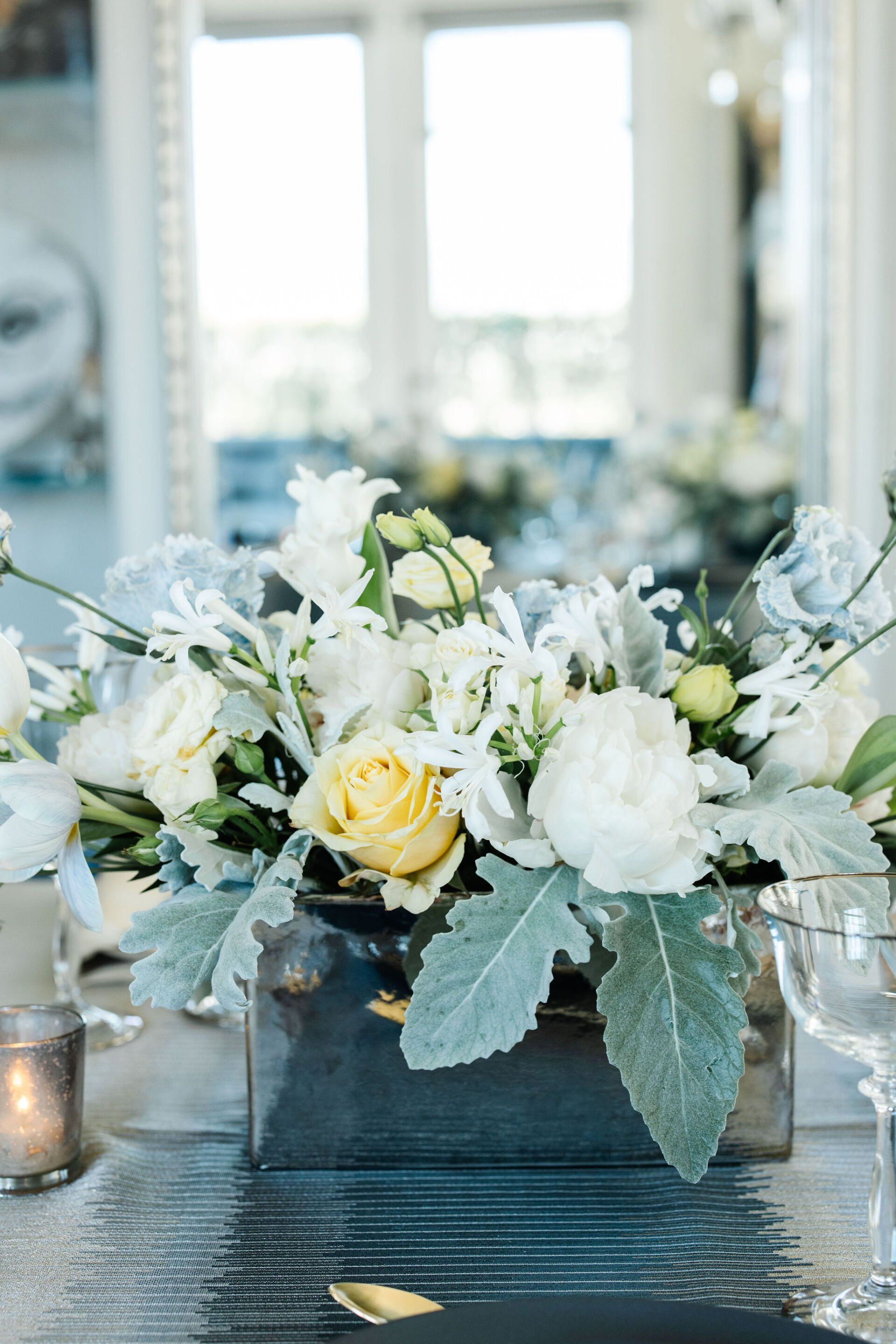 A vase filled with white flowers is on a table.