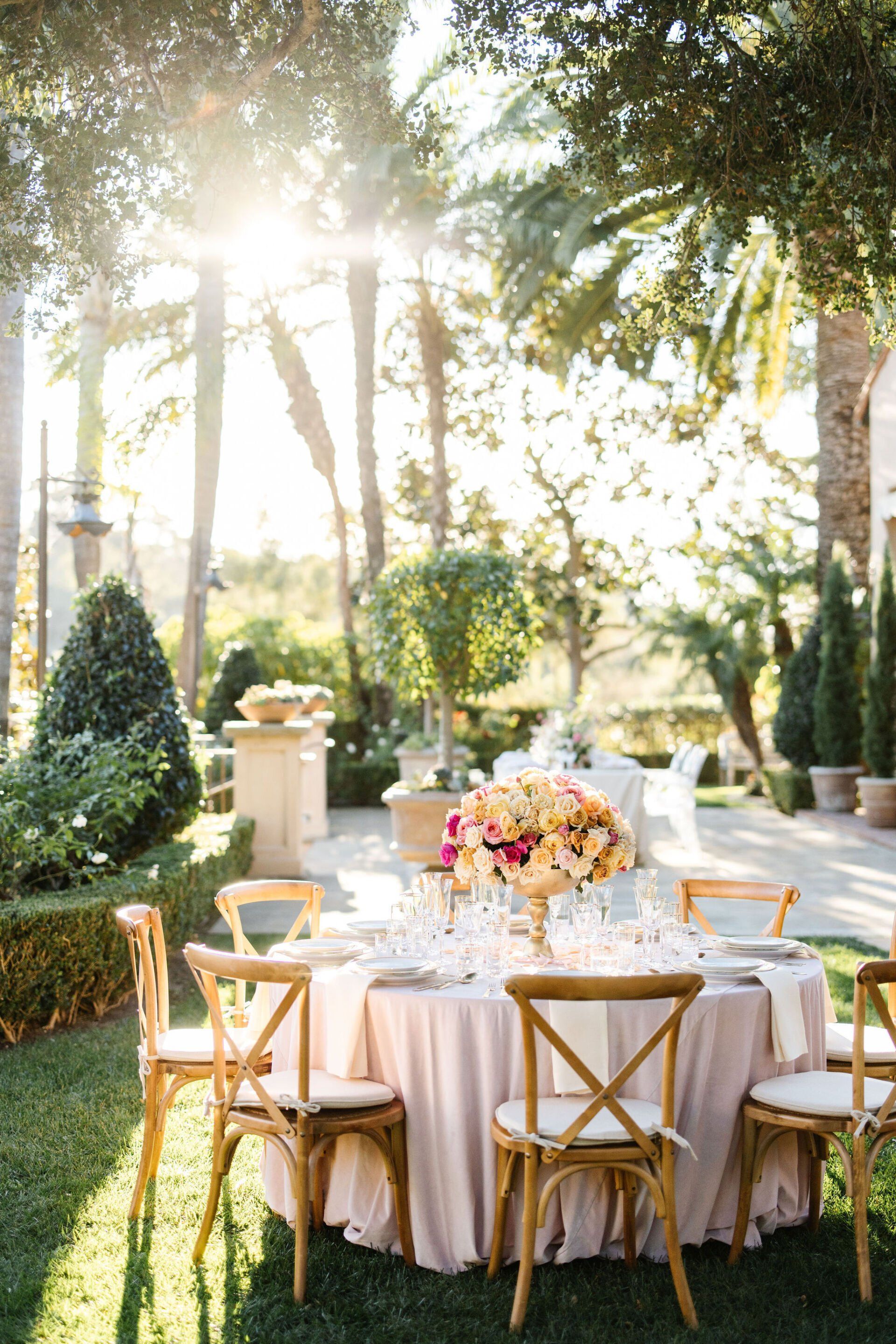 A table and chairs are set up in the grass for a wedding reception.